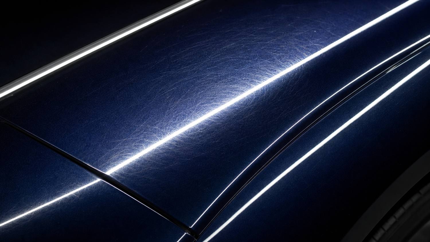 Swirl marks and wash scratches across dark paint before correction
