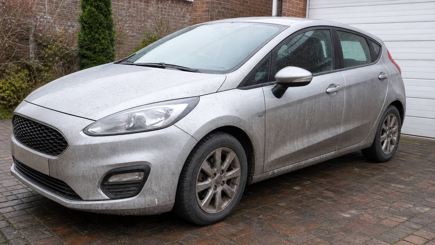A road-filmed silver hatchback before a full exterior detail